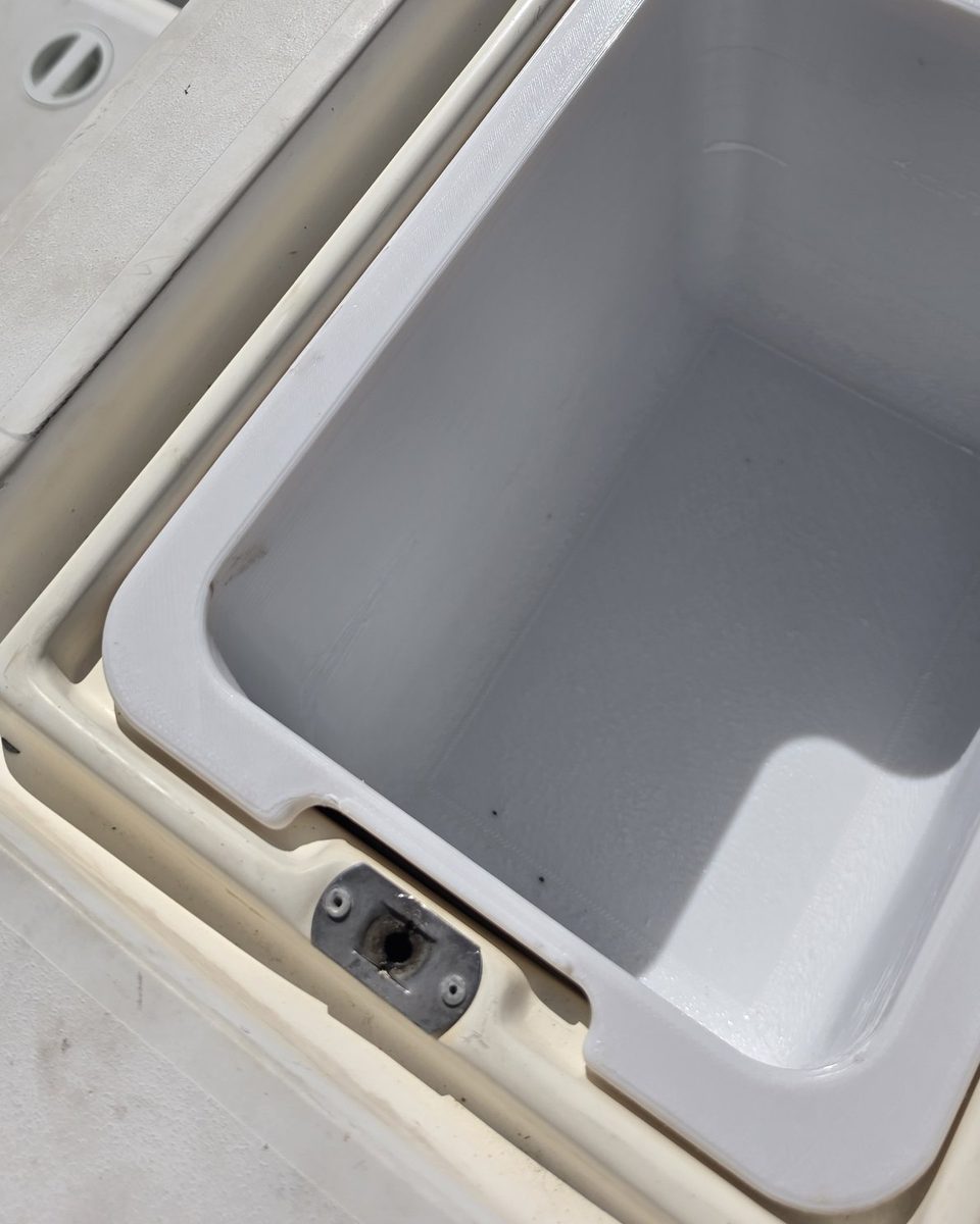 Close-up of the replacement box flange notched around the boat's stainless hatch latch plate