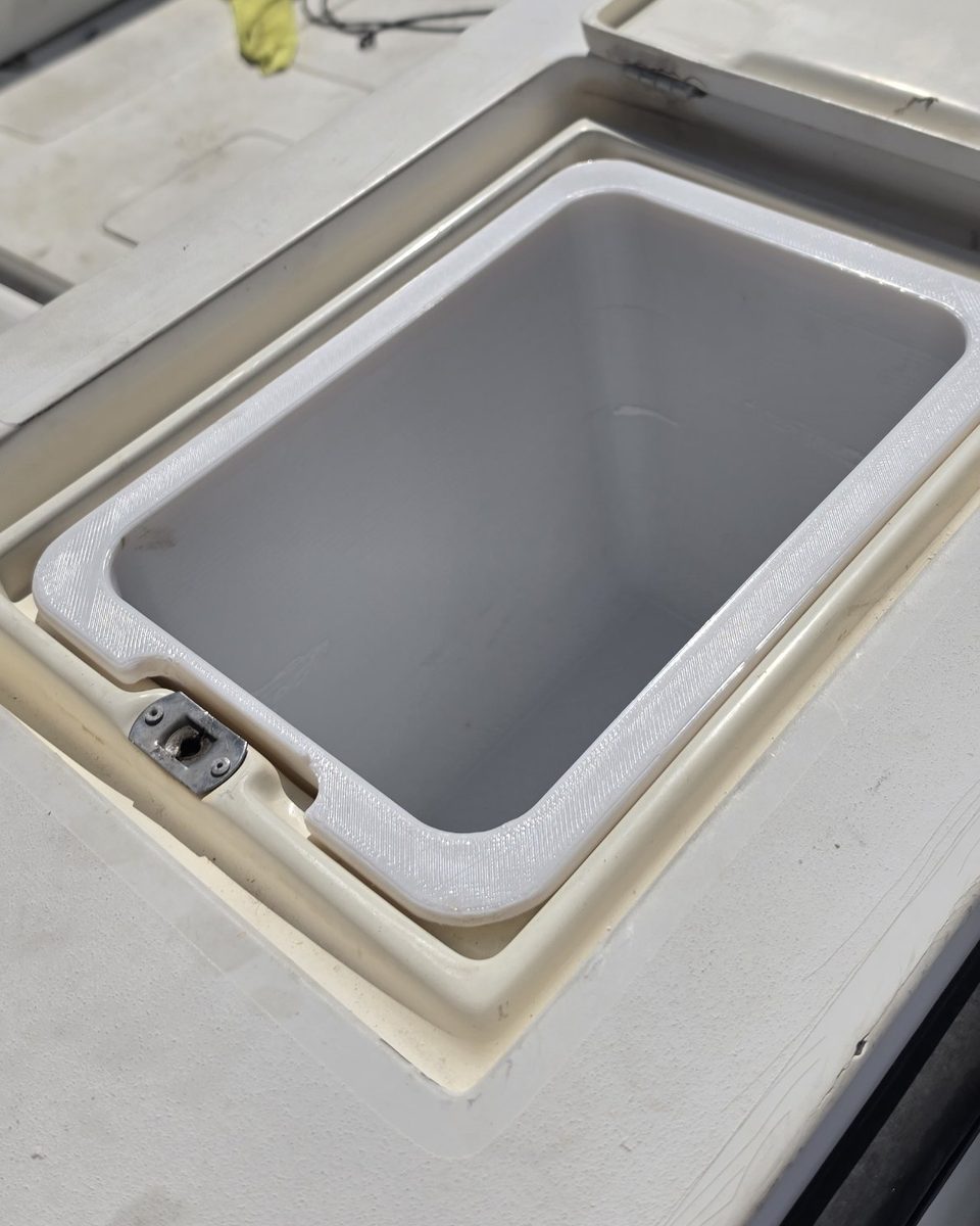 Custom storage box installed in the deck hatch of a center console boat, its flange sitting evenly in the original recess